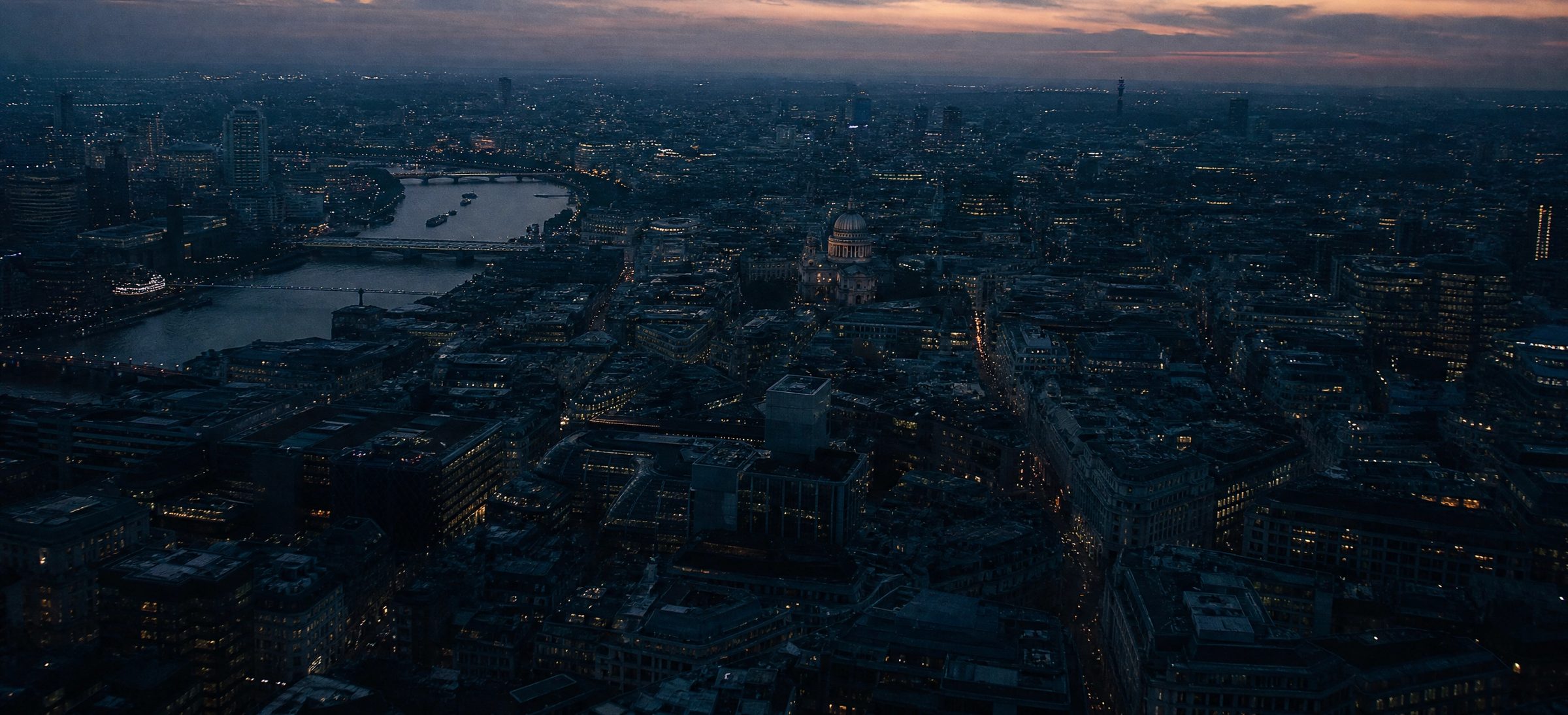 Aerial view of London at dusk, the Thames curving through the City